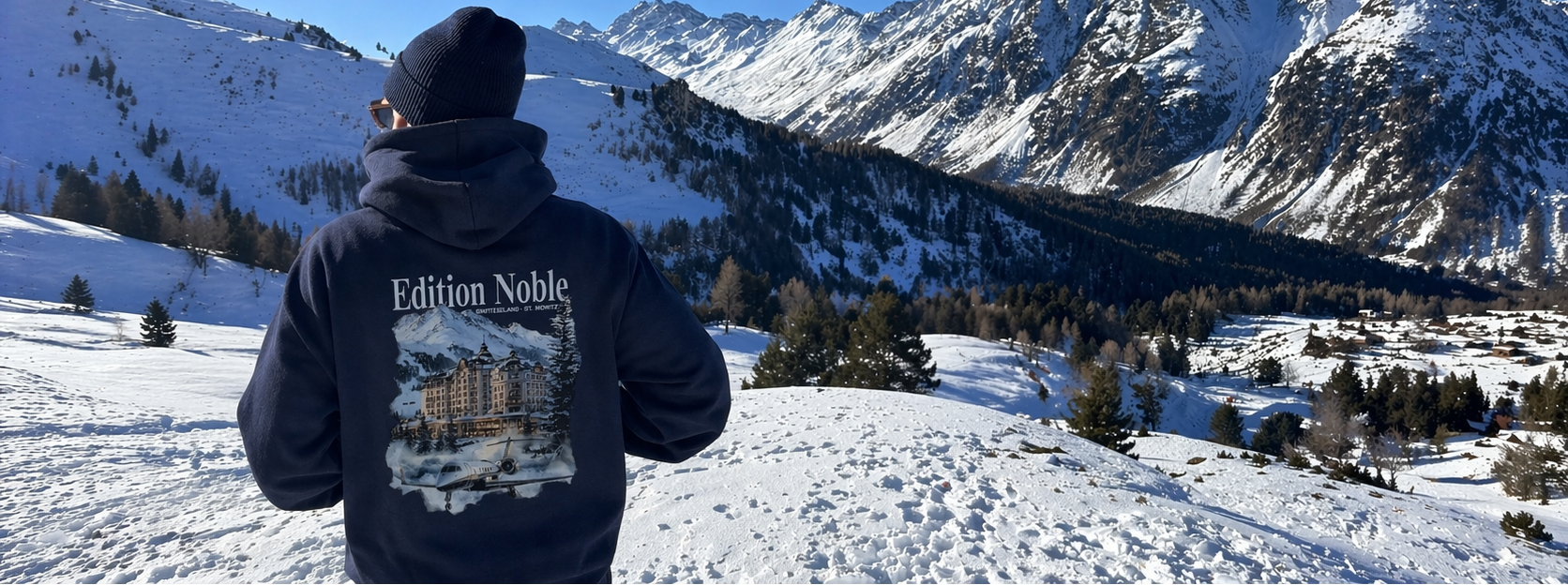 Person wearing an 'Edition Noble' Hoodie in a snowy mountain landscape
